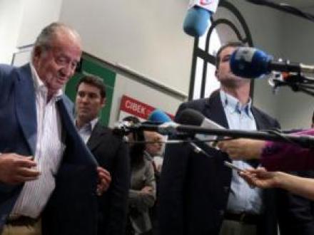 Spaniens kong Juan Carlos åbner sin jakke, for at vise at han er ved godt helbred
